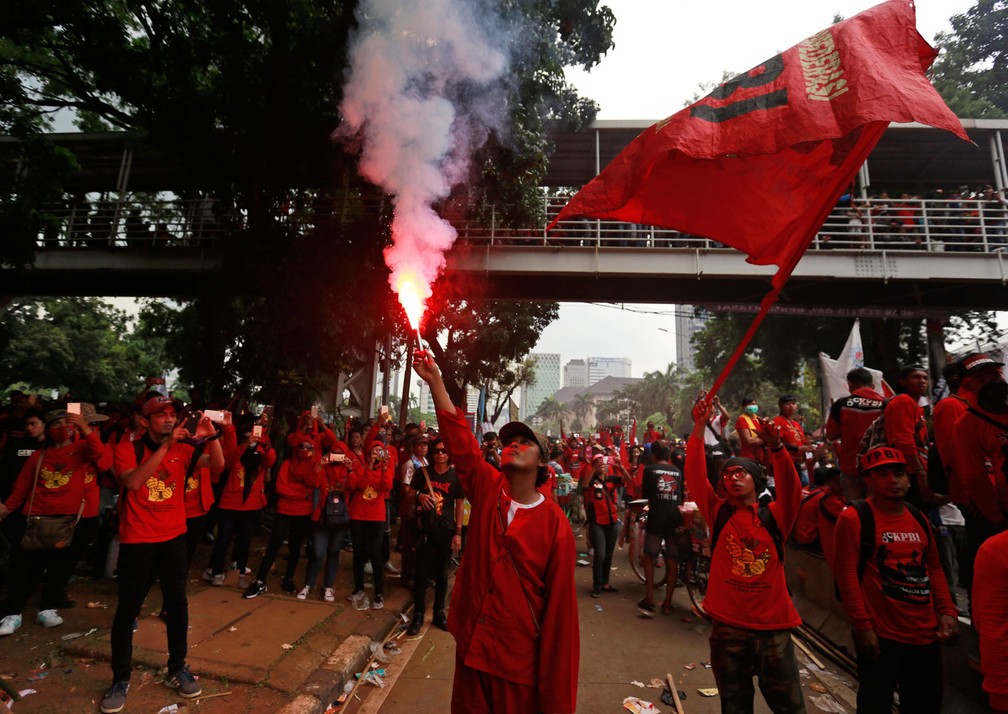 Manifestante acende sinalizador durante marcha do Dia do Trabalhador em Jacarta, na Indonésia, nesta segunda-feira, dia 1º de maio de 2017 (Foto: Dita Alangkara/AP)