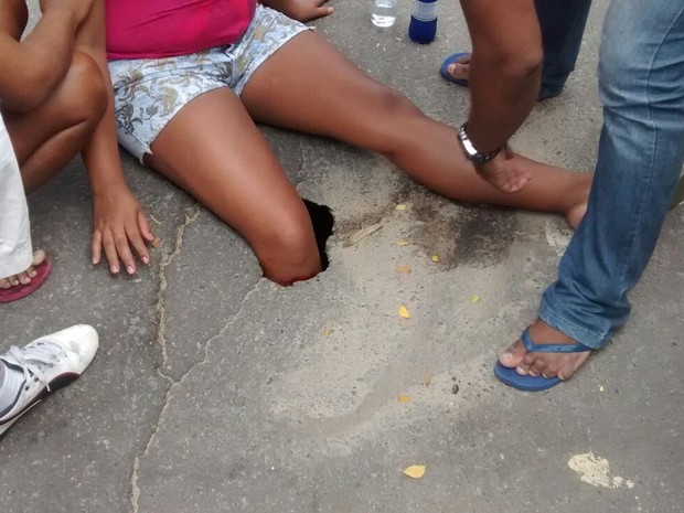 Mulher cai em buraco em rua de Vitória (Foto: VC no ESTV)