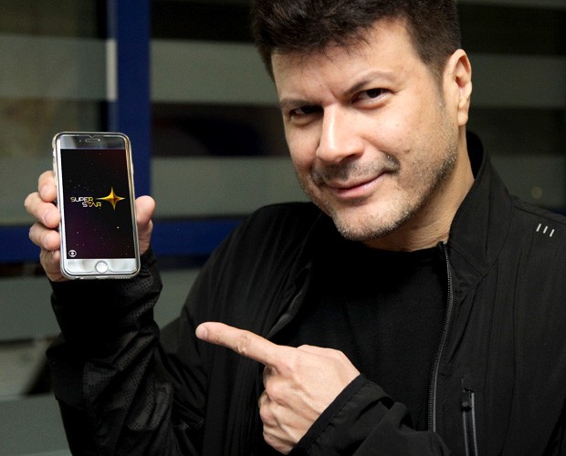 Paulo Ricardo mostra em seu celular o aplicativo do programa (Foto: Fabiano Battaglin / Gshow)
