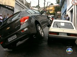 Carro roubado ficou pendurado em outro veículo após batida (Foto: Reprodução/TV Globo)