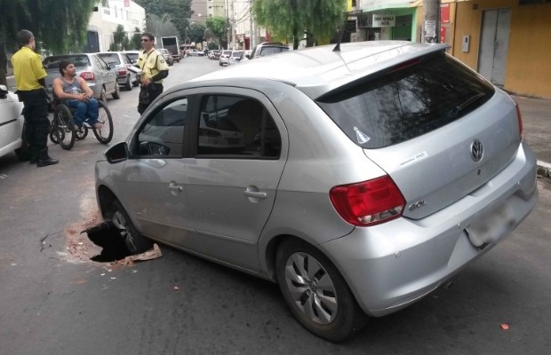 Carro fica preso em buraco na rua 8, centro de Goiânia, Goiás (Foto: Wildes Barbosa/O Popular)