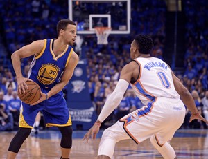 Stephen Curry observa o jogo marcado por Russell Westbrook (Foto: Reuters)