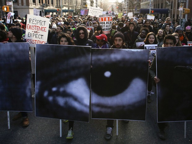 Manifestantes em Nova York carregam painéis durante protesto contra a violência policial contra negros, no sábado (13) (Foto: Reuters/Eduardo Munoz )