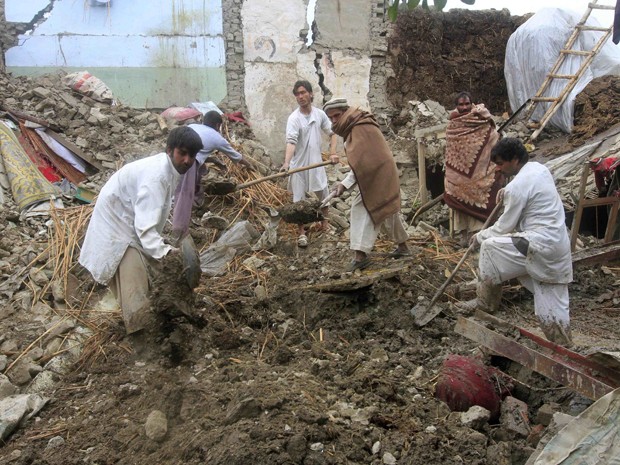Afegãos tentam retirar objetos de casa destruída no distrito de Behsud, na quarta-feira (25) (Foto: Reuters/Parwiz)