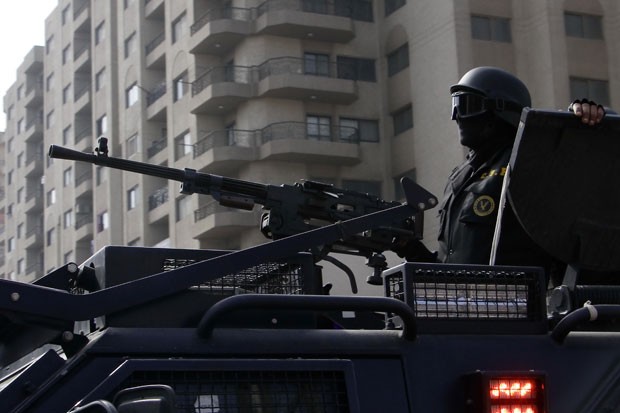 Membro das forças de segurança do governo egípcio patrulha subúrbio do Cairo durante protesto (Foto: Ahmed Abdel Fattah/AP)