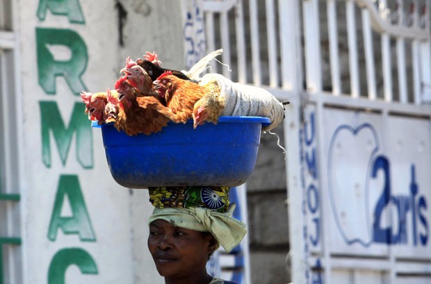 Mulher leva galinhas vivas sobre a cabeça enquanto caminha por Goma, na República Democrática do Congo, nesta sexta-feira (3) (Foto: James Akena/Reuters)