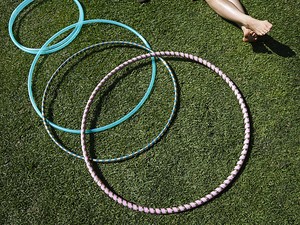 Jovem relaxa no gramado do Parque Balboa ao lado de bambolês (Foto: Gregory Bull/AP)