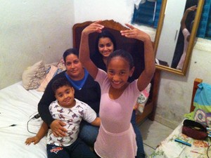 Beatriz ao lado da mãe e dos irmãos, no cômodo onde moram na Cracolândia  (Foto: Lívia Machado/G1)