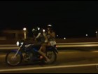 Trio em moto anda em alta velocidade e mulher acena para câmera; vídeo