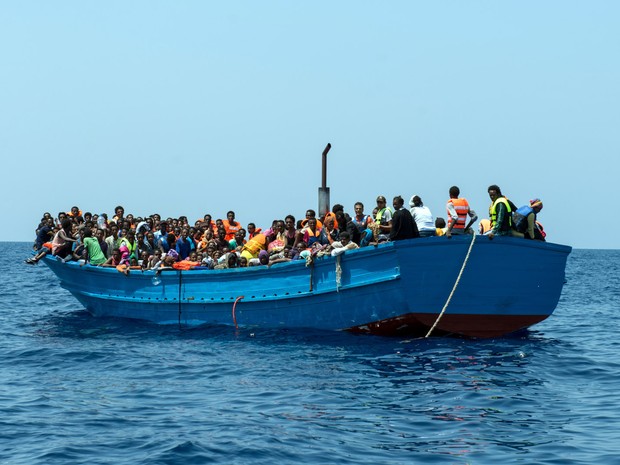Imigrantes são vistos em um barco de madeira antes de serem resgatados no Mar Mediterrâneo. Mais de 190 mil imigrantes desembarcaram na Europa este ano, e mais de 2 mil morreram durante tentativas de travessia (Foto: Gabriele Francois Casini/MSF/via AP) Imigrantes são vistos em um barco de madeira antes de serem resgatados no Mar Mediterrâneo. Mais de 190 mil imigrantes desembarcaram na Europa este ano, e mais de 2 mil morreram durante tentativas de travessia (Foto: Gabriele Francois Casini/MSF/via AP)