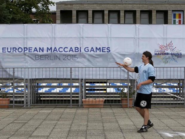 Voluntário brinca com uma bola do lado de fora do Parque Olímpico, durante os preparativos para os 14º Jogos Macabeus Europeus, em Berlim, na segunda (27) (Foto: Reuters/Fabrizio Bensch)