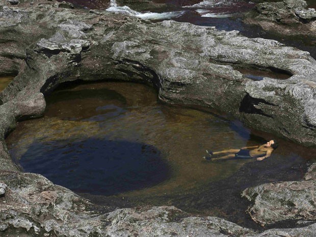 Homem nada no Caño Cristales (Foto: Jose Miguel Gomez/Reuters)