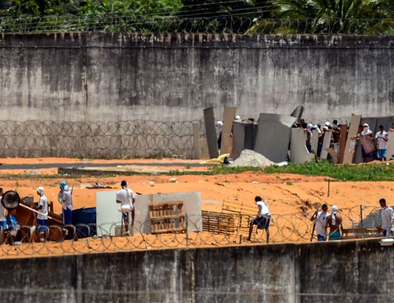 prisioneiros preparam-se para o confronto usando escudos improvisados ​​e armas no Centro Penitenciário de Alcacuz, perto de Natal, no Rio Grande do Norte (Foto: Andressa Anholete/AFP)