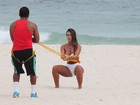 Nicole Bahls usa sainha branca para se exercitar na praia