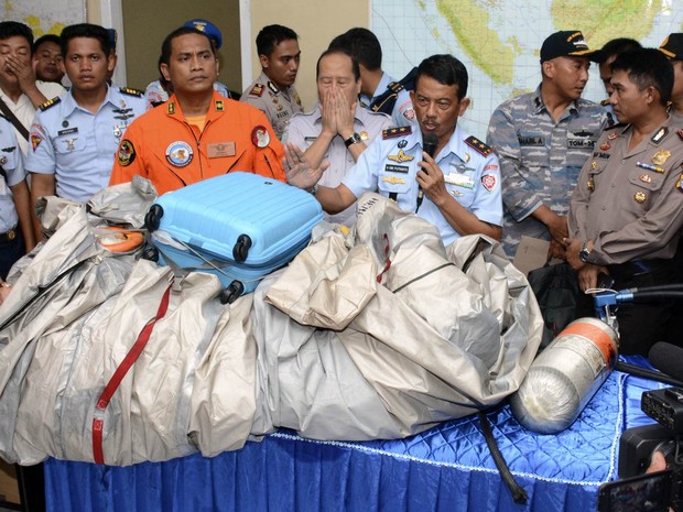 30/12 - Comandante indonésio apresenta objetos retirados do mar que pertenciam ao voo 8501 da AirAsia, como uma mala azul e o que parece ser um tanque de oxigênio, na base aérea de Pangkalan Bun (Foto: Dewi Nurcahyani/AP)