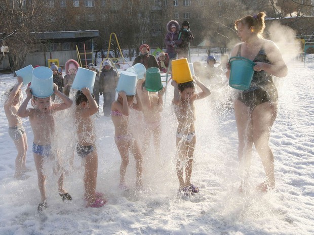 Crianças se banham com água gelada ao lado de uma supervisora no frio de -23° C em um jardim de infância de Krasnoyarsk, na Rússia. A instituição funciona há 15 anos com técnicas extremas para manter os pequenos com a saúde em dia. (Foto: Ilya Naymushin/Reuters)