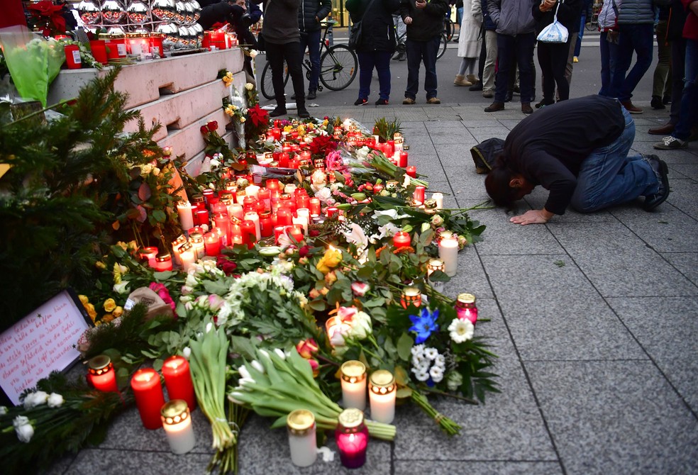 Homem faz oração nesta terça-feira (20) em memorial que homenageia as vítimas do ataque com caminhão que deixou mortos em Berlim na véspera (Foto: John MacDougall/AFP)