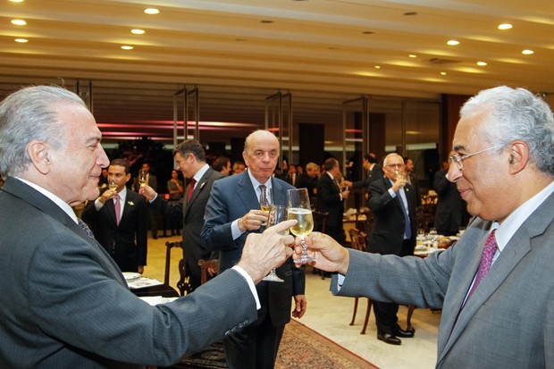 O primeiro-ministro de Portugal, António Costa (dir.), durante brinde em um jantar com o presidente Michel Temer (esq.); ao fundo, o ministro José Serra (centro) (Foto: Beto Barata/PR)