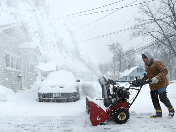 Homem retira neve da entrada de sua garagem em Derry, New Hampshire, na segunda-feira (2) (Foto: AP Photo/Charles Krupa)