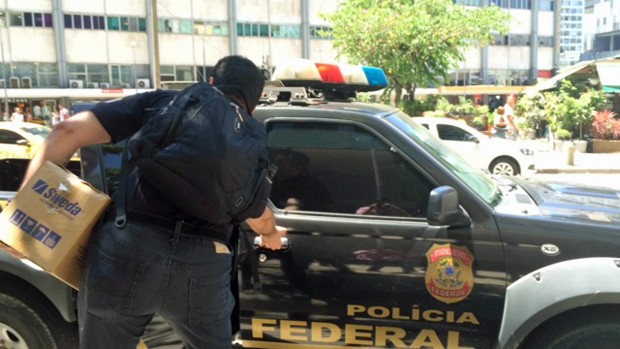 Policial Federal deixa prédio do escritório de Eduardo Cunha, no Centro do Rio, carregando caixa (Foto: Matheus Rodrigues/G1)
