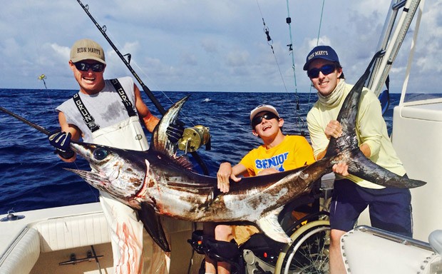 Logan Prickett, de 19 anos, posa entre amigos com o peixe que fisgou usando uma vara de pescar elétrica (Foto: Hunter Mills/Florida Keys News Bureau/AP)