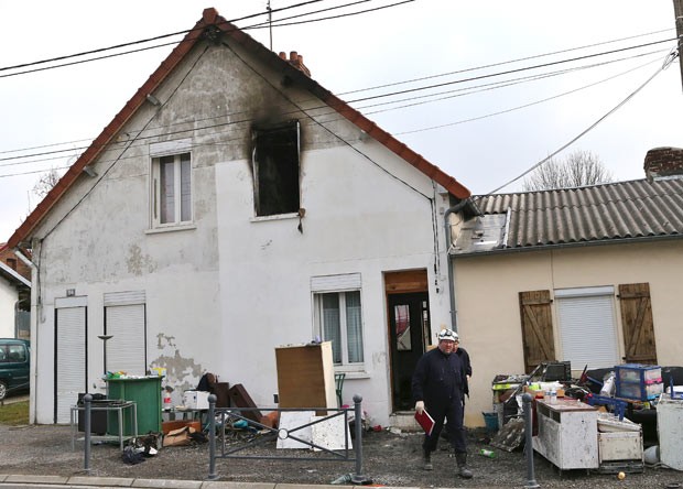 Bombeiro em frente ao prédio em que as cinco crianças morreram neste domingo (31) na cidade francesa de Saint-Quentin (Foto: AFP)