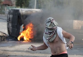 Em foto do dia 30 de outubro, palestino mascarado lança pedra contra forças de segurança israelenses em Jerusalém (Foto: Ahmad Gharabçi/AFP)