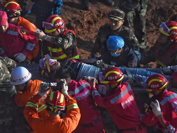 Equipes de resgate retiram jovem de 19 anos que foi encontrado vivo nesta quarta-feira (23) no local de deslizamento de terra que cobriu uma grande área em Shenzhen, na China, no domingo (20) (Foto: Jin Liangkuai/Xinhua News Agency via AP)