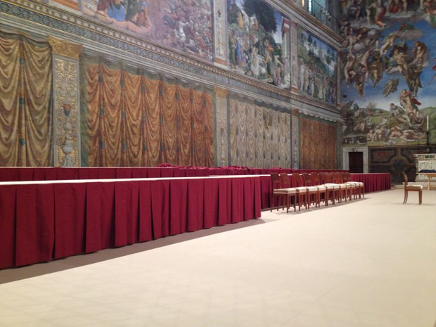 Mesas e cadeiras vermelhas que serão usadas pelos cardeais durante o conclave na Capela Sistina, no Vaticano (Foto: Juliana Cardilli/G1)