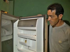 O eletricista Mario Ferreira Lima mostra geladeira vazia na casa em que mora com o filho de 12 anos (Foto: TV Globo/Reprodução)