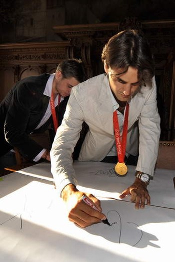 Com a medalha de ouro olímpica no peito, conquistada em Pequim, Federer dá autógrafo na Basiléia, no seu primeiro retorno ao país após a conquista, semana passada. Ao fundo, seu parceiro de façanha e compatriota, Stanislas Wawrinka (Foto: Arquivo)