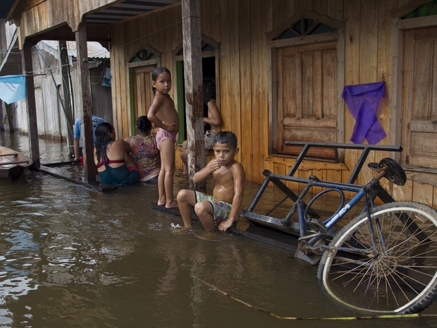 Crianas olham da varanda de sua casa alagada pela enchente em Anam, no Amazonas (Foto: Bruno Kelly/Reuters)