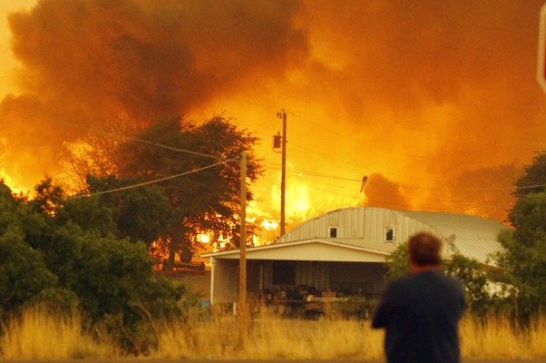 Morador observa sua casa ser destruída pelo fogo na cidade de Glenn Ilah, localizada nas proximidades de Yarnell Hill, nos Estados Unidos. Incêndio florestal matou dezenove bombeiros que trabalhavam na área (Foto: AP Photo/The Arizona Republic, David Kadlubowski)
