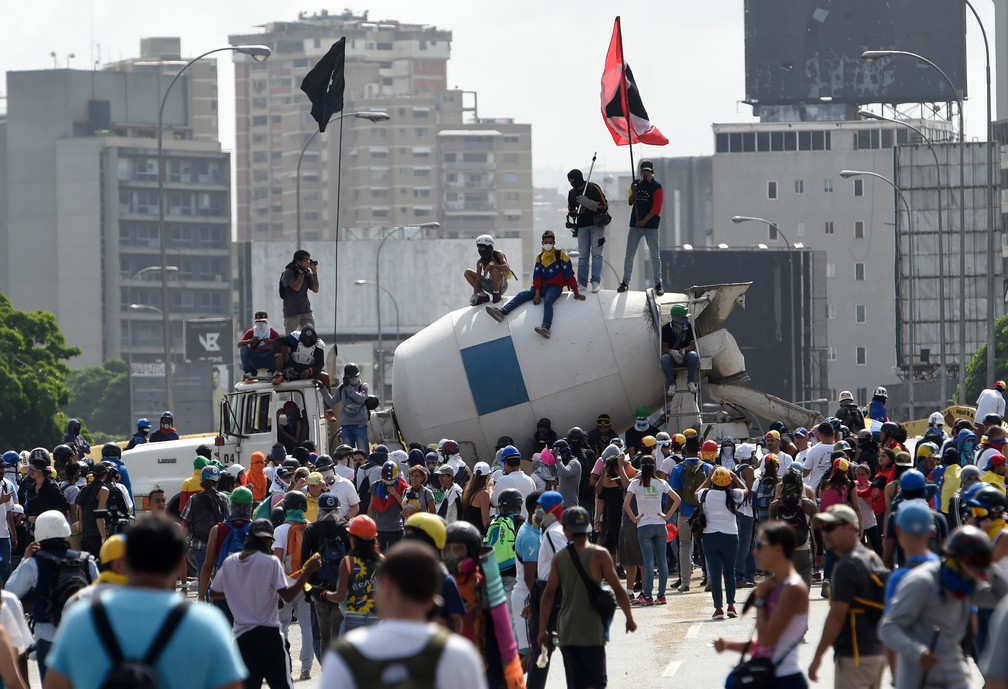 Manifestantes de oposição bloqueiam rodovia durante protesto em Caracas neste sábado (27) (Foto: Juan Barretp/AFP)