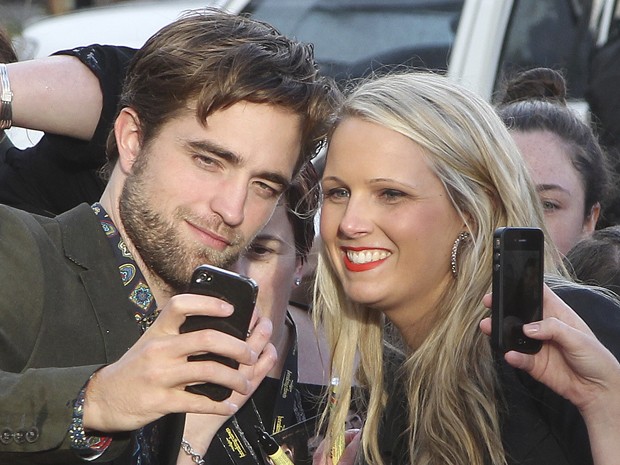 Robert Pattinson posa com fã durante lançamento de 'A saga Crepúsculo: Amanhecer - parte 2' em Sydney, na Austrália, nesta segunda-feira (22) (Foto: AP/Rob Griffith)