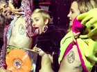 Miley Cyrus levanta blusa e deixa parte do seio à mostra