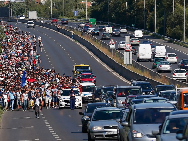 Migrantes marcham por uma estrada nos arredores de Budapeste, na Hungria, para a fronteira com a Áustria. Uma lei aprovada nesta sexta (4) pelo Parlamento da Hungria prevê penas de até três anos de prisão para o cruzamento ilegal de suas fronteiras (Foto:  Laszlo Balogh/Reuters)