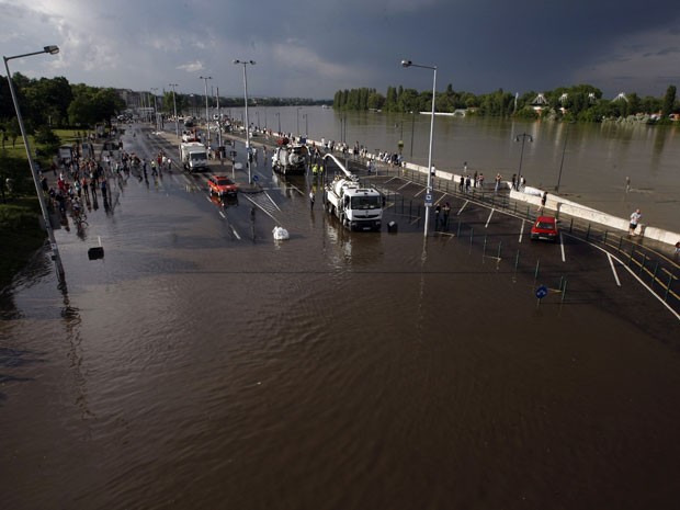 Policiais e bombeiros interditaram rodovia inundada em Budapeste neste sábado (8) (Foto: FERENC ISZA/AFP)