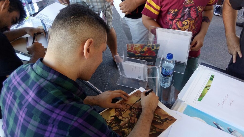 Quadrinista Thony Silas autografa quadrinhos trazidos por fãs à 'Invasão CCXP Tour' (Foto: Marina Meireles/G1)