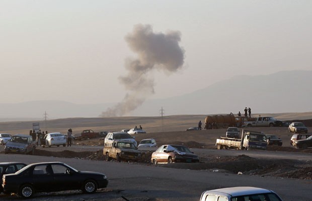 Fumaça sobe ao longe após ataques aéreos nos arredores de Irbil, no norte do Iraque, nesta sexta-feira (8). A força aérea iraquiana, assim como os EUA, bombardearam áreas controladas pelo Estado Islâmico (Foto: Khalid Mohammed/AP)
