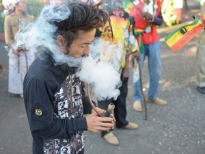 Um rastafari chamado Bongho Jatusy fuma maconha em frente a museu da erva na Jamaica (Foto: AP Photo/David McFadden)