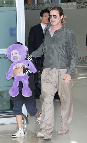 Brad Pitt com o filho Pax em aeroporto em Seul, na Coréia do Sul (Foto: Jun Sato/ Getty Image)
