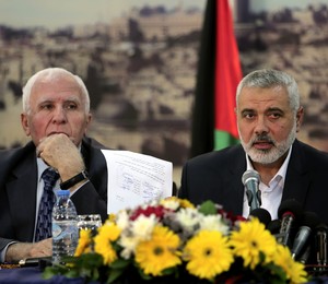 O primeiro-ministro da Faixa de Gaza, Ismail Haniyeh (dir.), líder do Hamas, mostra acordo assinado para formar um governo de coalizão na Palestina. Ao seu lado, Azzam al-Ahmad, um dos líderes do Fatah, grupo que governa a Cisjordânia (Foto: Adel Hana/AP) O primeiro-ministro da Faixa de Gaza, Ismail Haniyeh (dir.), líder do Hamas, mostra acordo assinado para formar um governo de coalizão na Palestina. Ao seu lado, Azzam al-Ahmad, um dos líderes do Fatah, grupo que governa a Cisjordânia (Foto: Adel Hana/AP)