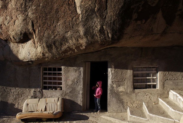 Lucero, a neta de Benito Hernández, é vista à porta da casa sob a enorme rocha (Foto: Daniel Becerril/Reuters)