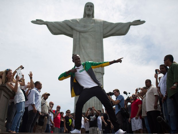 Bolt faz o gesto que é sua 'marca característica' em visita ao Cristo Redentor (Foto: Felipe Dana/AP)