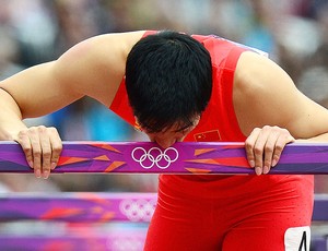 Liu Xiang beija a barreira após queda na prova dos 110m com barreiras (Foto: AFP)