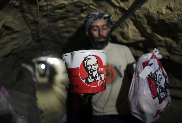 Homem usa túnel para levar pedidos do Kentucky Fried Chicken do Egito até a Faixa de Gaza (Foto: AFP)