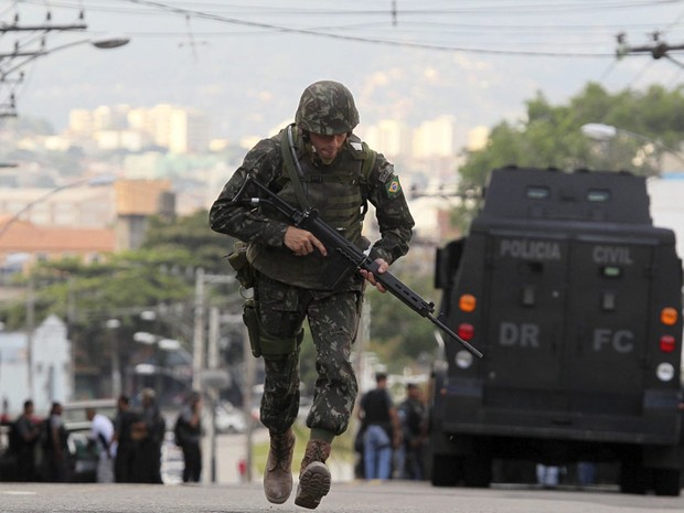 Soldado do Exército corre no Complexo do Alemão, no começo da manhã deste domingo.  (Foto: Sergio Moraes/Reuters)