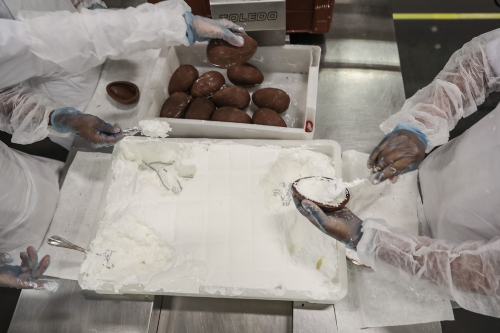 Funcionárias preenchem as cascas de chocolate com marshmallow na fábrica de chocolates do Grupo CRM, em Extrema (MG) (Foto: Fábio Tito/G1)