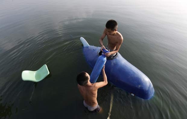 Em 2011, o agricultor chinês Zhang Wuyi construiu um submarino caseiro. Ele realizou teste com sucesso do equipamento no lago Moshui em Wuhan, na província de Hubei, na China. (Foto: Jason Lee/Reuters)